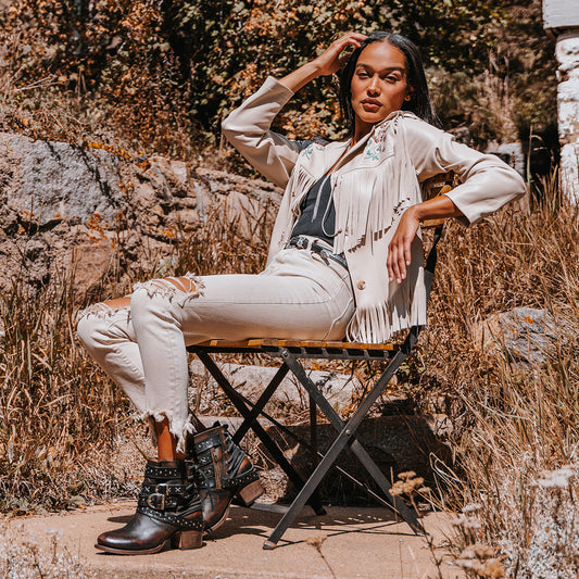 FREEBIRD women's Caspian black multi leather bootie with back tie lacing, round toe construction and adjustable shaft belts lifestyle image