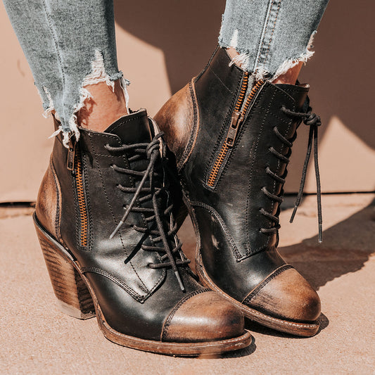 Black DAME leather booties with a pointed cap toe, multi-colored inverted lacing, and a stacked high heel.