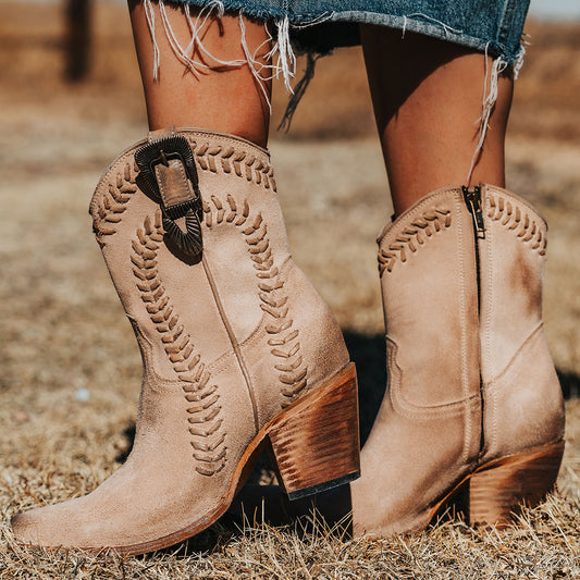 FREEBIRD women's Freya beige suede bootie with whip stitch detailing, a snip toe silhouette and decorative vintage buckle. Finished with an inside working zipper.