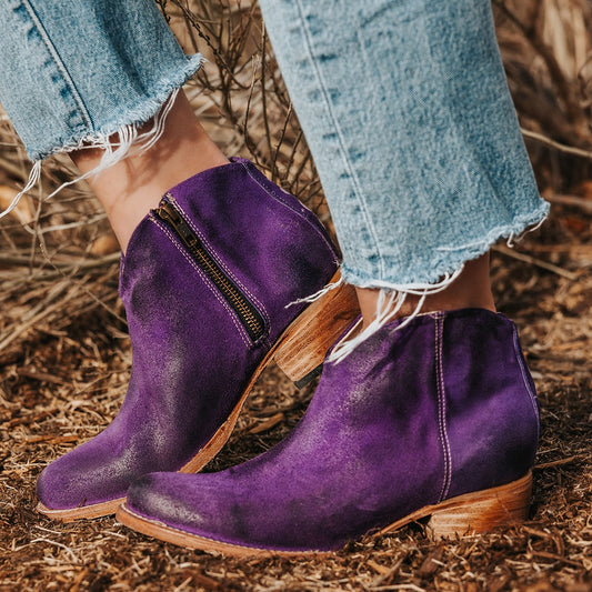 FREEBIRD women's Hippy purple suede low heeled bootie with a working brass zip closure, heel seam embroidery, almond toe, and front dip detailing