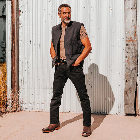 FREEBIRD men's James brown leather boot with traditional Western stitching, tread sole and leather pull straps lifestyle image