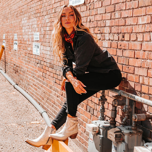 FREEBIRD women's Morgan beige leather ankle bootie with silver stud embellishments, gore detailing, and buckle straps lifestyle image