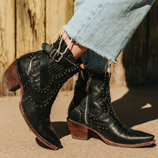 FREEBIRD women's Morgan black leather ankle bootie with silver stud embellishments, gore detailing, and buckle straps