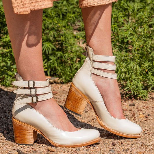 Freebird women's RANDI cream patent leather ankle strap heels with a round toe, three adjustable metal buckles, and a back zipper.