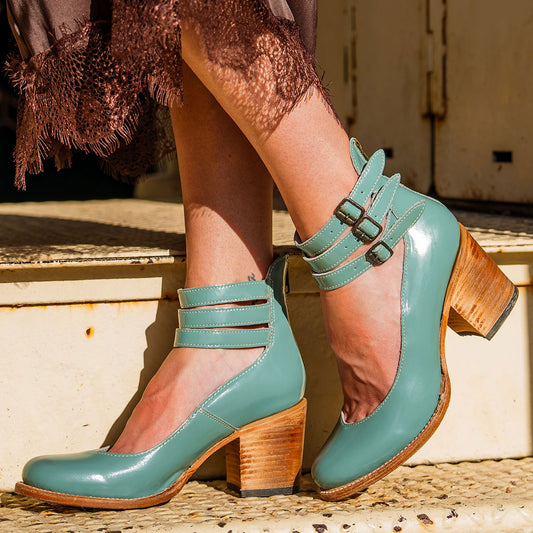 Freebird women's RANDI teal patent leather ankle strap heels with a round toe, three adjustable metal buckles, and a back zipper.