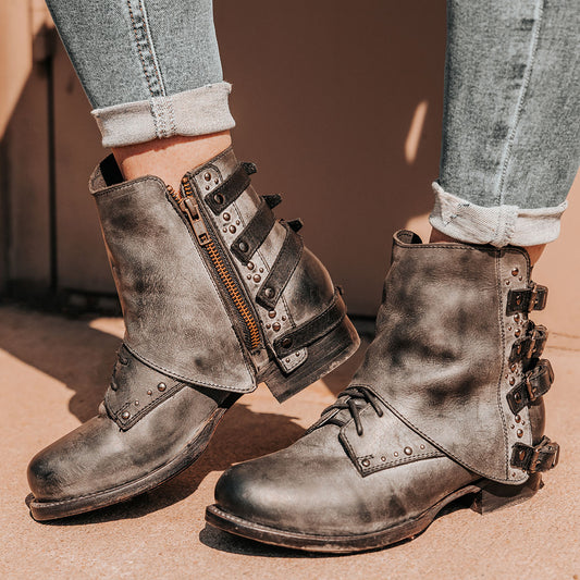 Black RYNN pointed-toe leather booties featuring intricate geometric overlays and a functional side zipper.