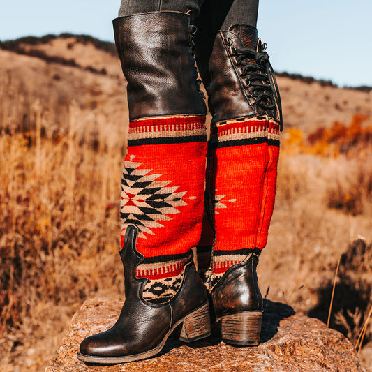 Black SERAPE knee-high leather boots with colorful woven thread, lace-up details, and low stacked heels.