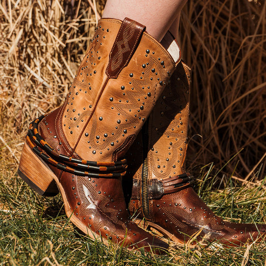 Tan WISTERIA tall leather western boots with harness, decorative stitching, and metal studs on a wood-block heel.