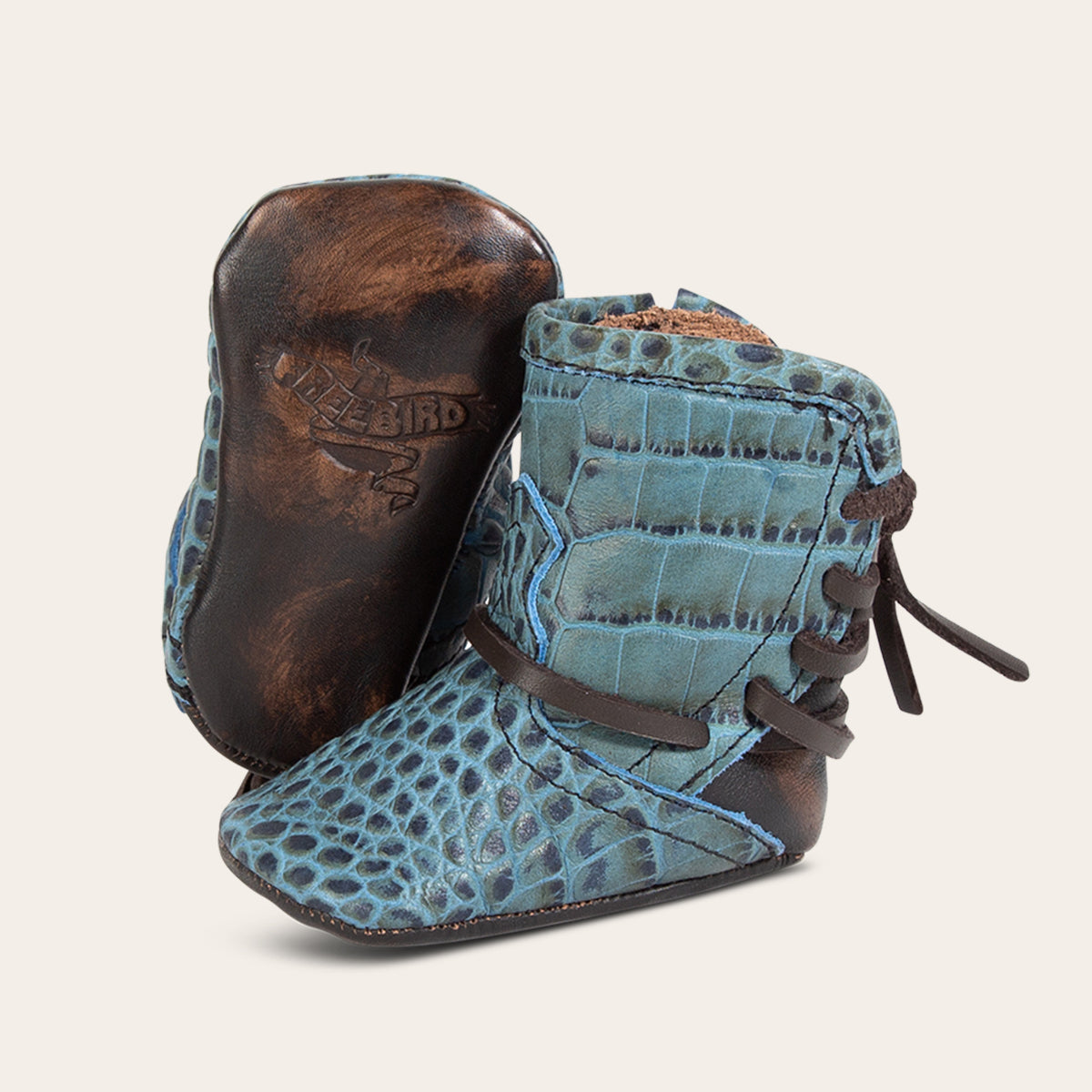 front view showing contrasting leather lace detailing and soft leather imprinted sole on FREEBIRD infant baby coal turquoise croco leather bootie 