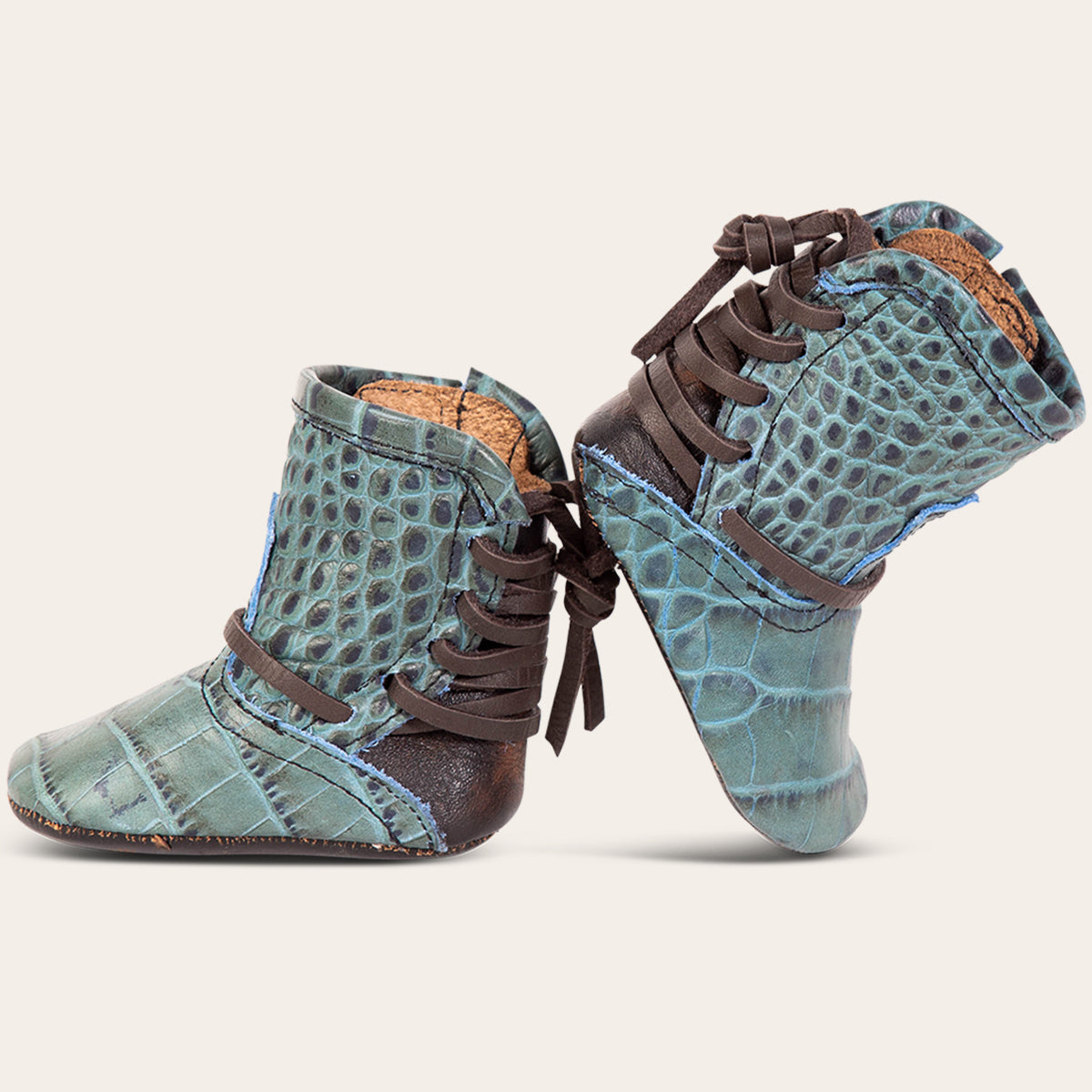 side view showing contrasting back lace detailing on FREEBIRD infant baby coal turquoise croco leather bootie 