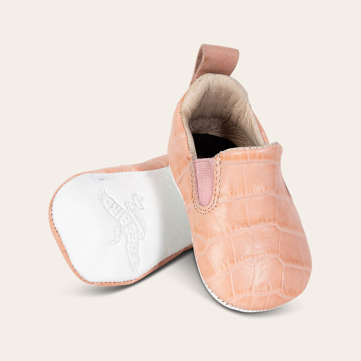 front view showing pull tab and side elastic panel and soft leather imprinted sole on FREEBIRD infant baby kicks pink croco leather shoe