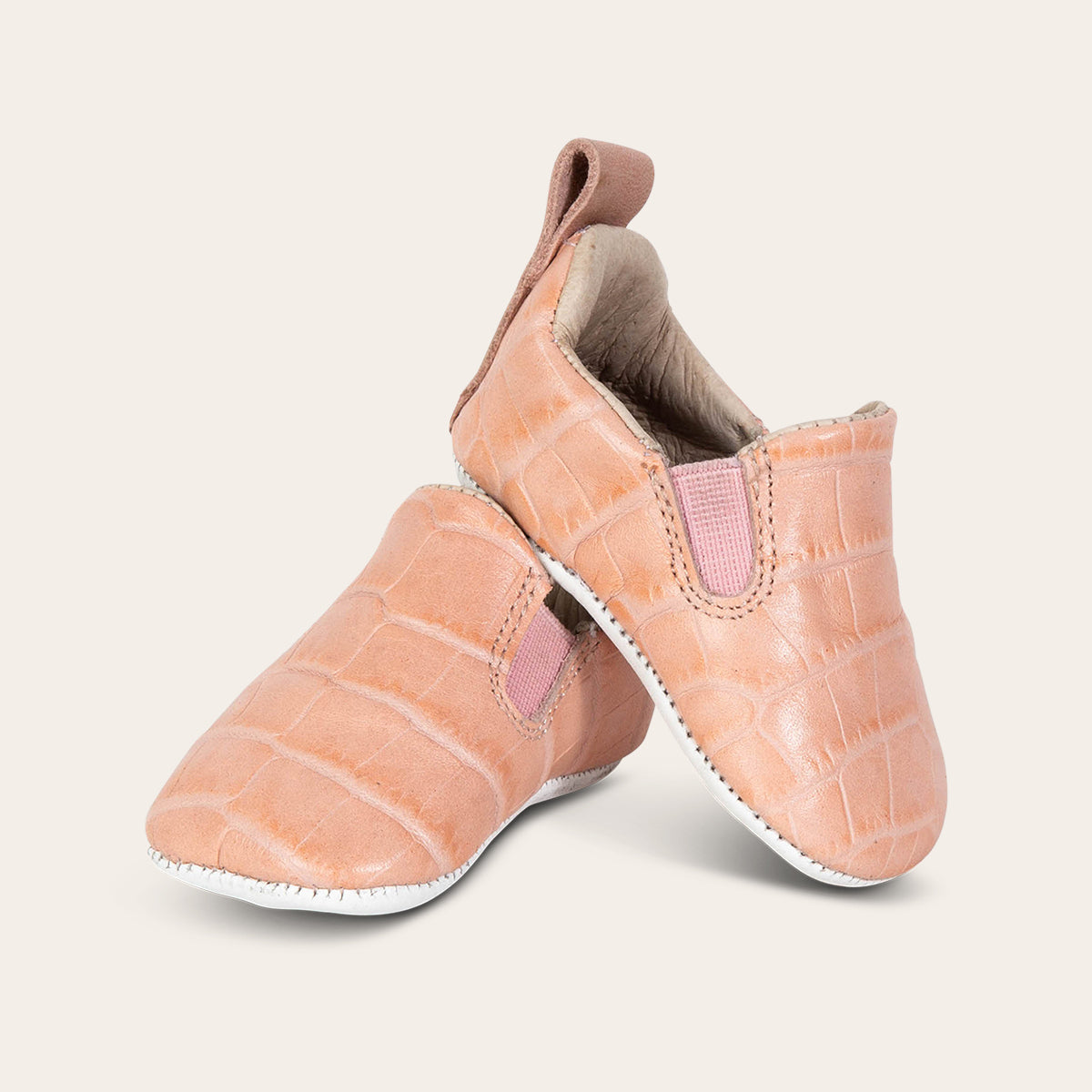 front view showing heel pull tab and side elastic panel on FREEBIRD infant baby kicks pink croco leather shoe