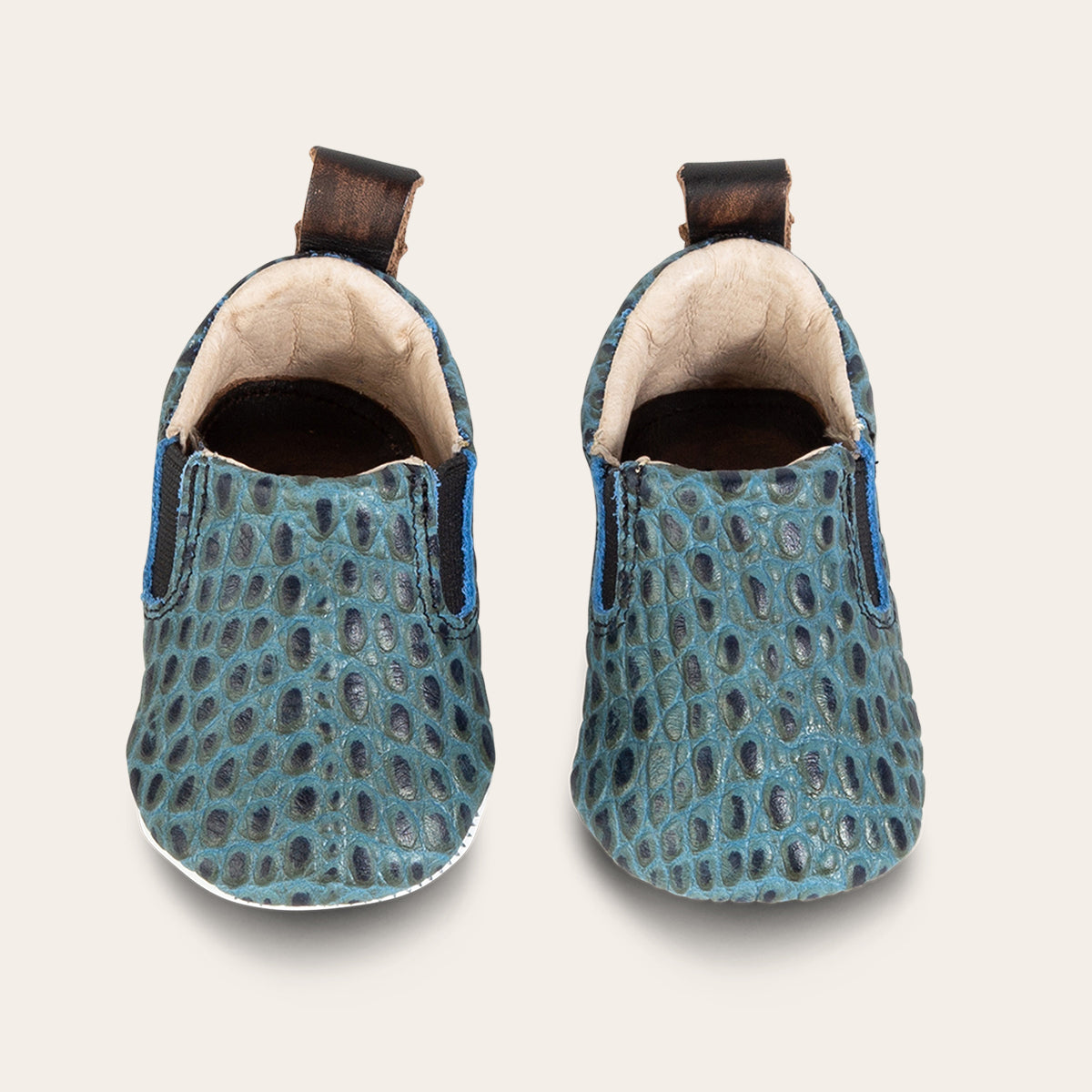 top view showing heel pull tab and side elastic panel on FREEBIRD infant baby kicks turquoise croco leather shoe