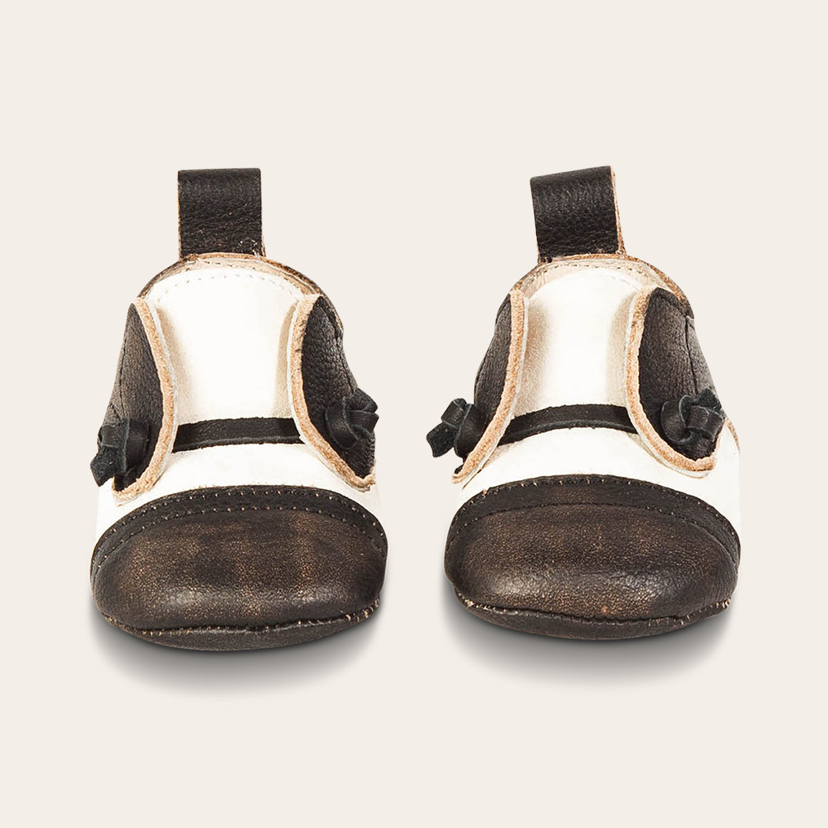 Front view showing decorative knotted leather lace and leather heel pull on FREEBIRD infant baby Mabel black white leather shoe