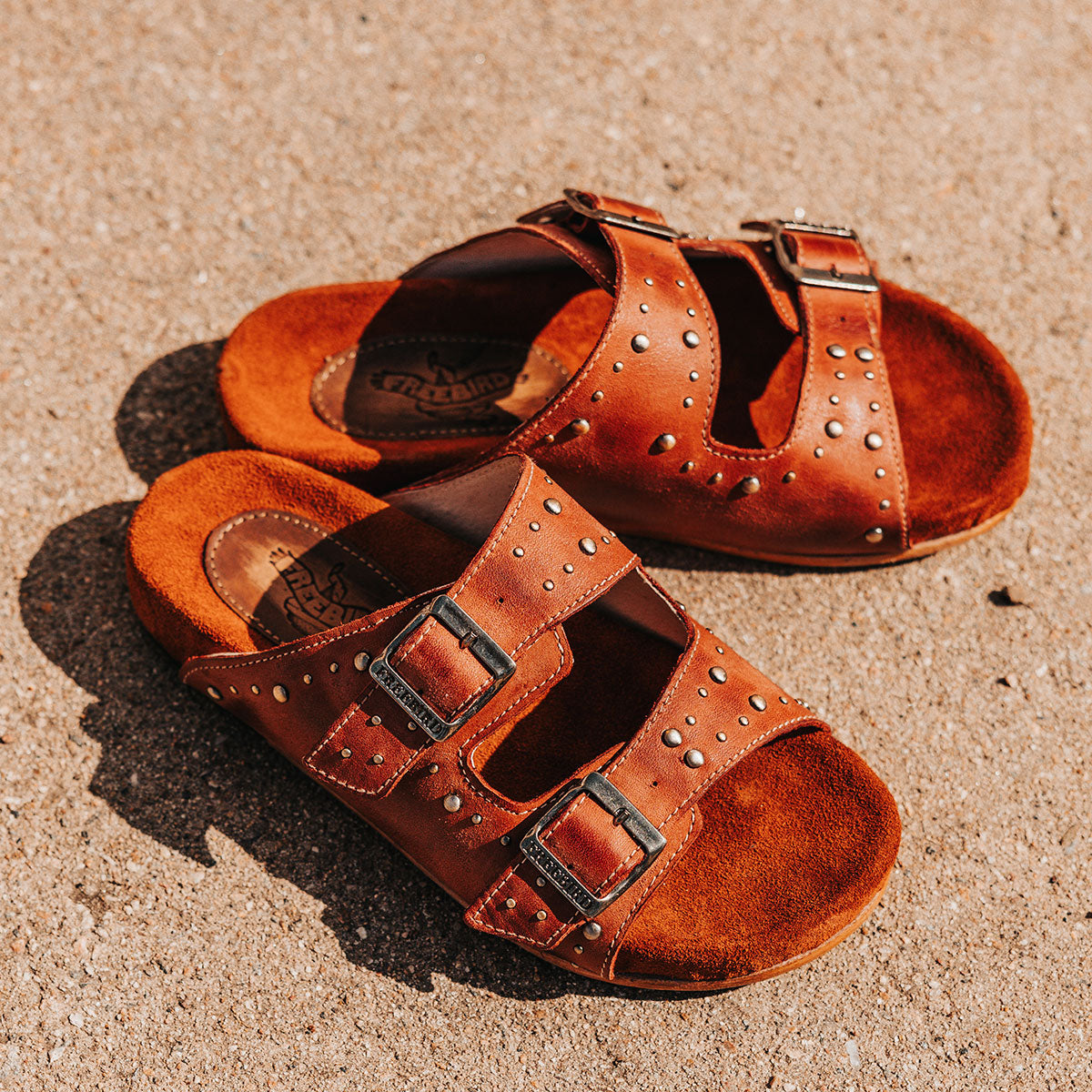 FREEBIRD women's Asher rust sandal with adjustable belt buckles, a suede footbed and silver embellishments