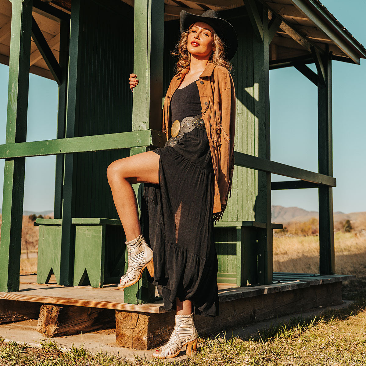 FREEBIRD women's Bela beige leather sandal with laser cut leather, braided accents and a working brass zip closure lifestyle image