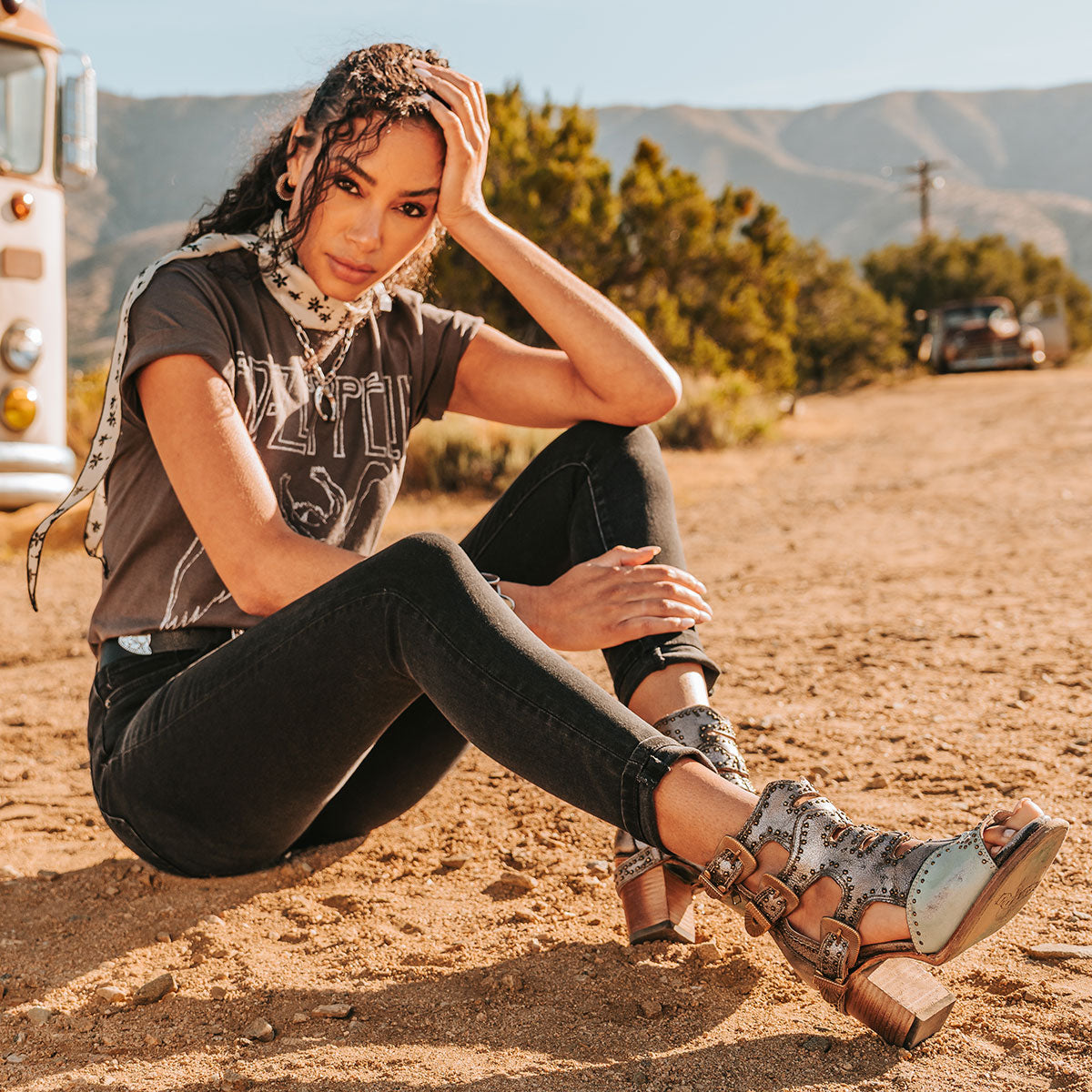FREEBIRD women's Bradshaw blue/silver two-toned leather sandal with adjustable gold buckle hardware, stud embellishments and cut out detailing. Finished on a lifted high heel lifestyle