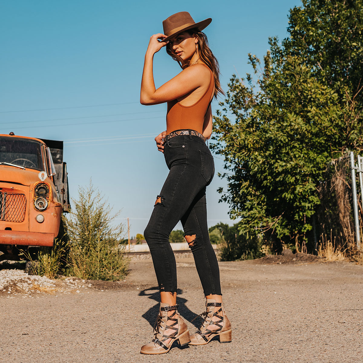 FREEBIRD women's Cheyenne taupe multi laser cut criss-cross leather lace up front silver buckle detail ankle bootie lifestyle image