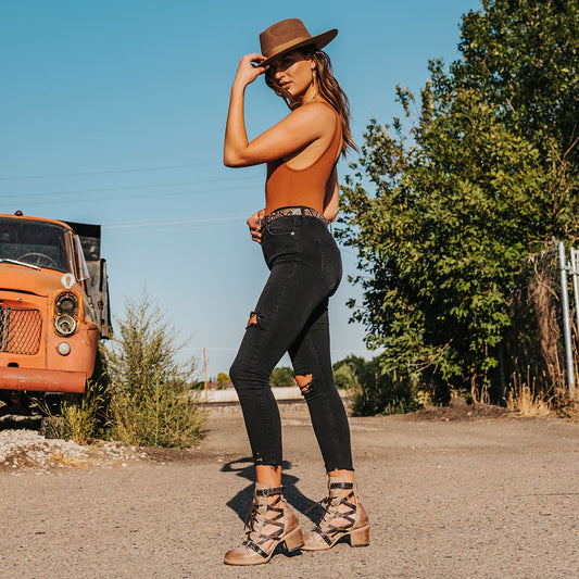 FREEBIRD women's Cheyenne taupe multi laser cut criss-cross leather lace up front silver buckle detail ankle bootie lifestyle image