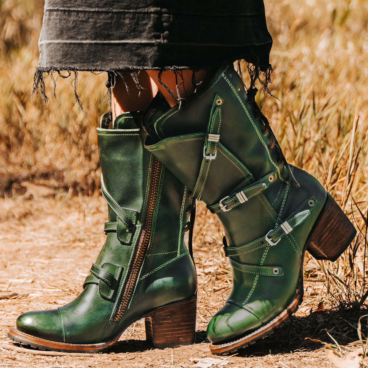 Green CORA leather booties featuring a back-lacing design, slouchy silhouette, and adjustable silver buckle straps.