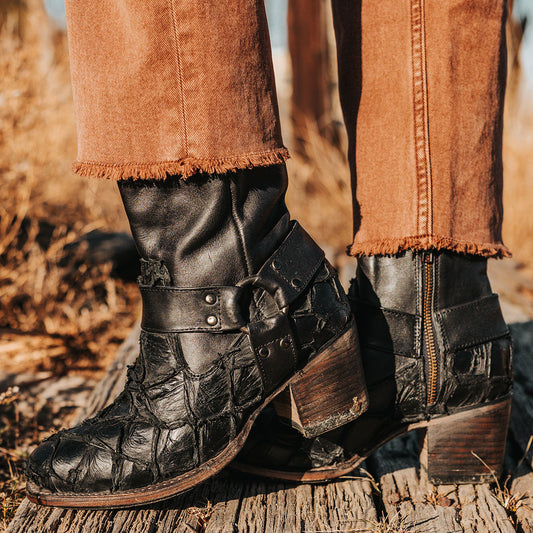 FREEBIRD women's Darcy black fish leather bootie with a studded ankle harness, leather pull straps, an inside zip closure and a square toe