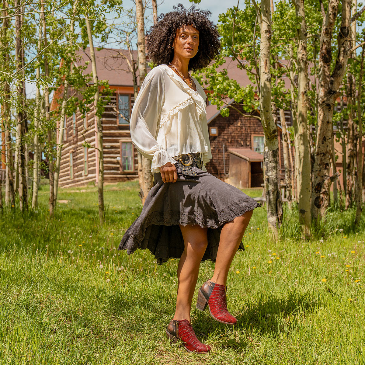 Red croco DETROIT heeled booties with back zip, inverted heel, front cutout dip, and full-grain leather texture lifestyle