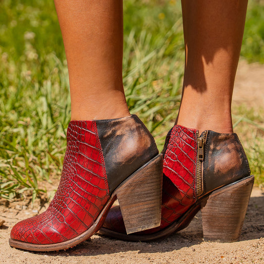 Red croco DETROIT heeled booties with back zip, inverted heel, front cutout dip, and full-grain leather texture.