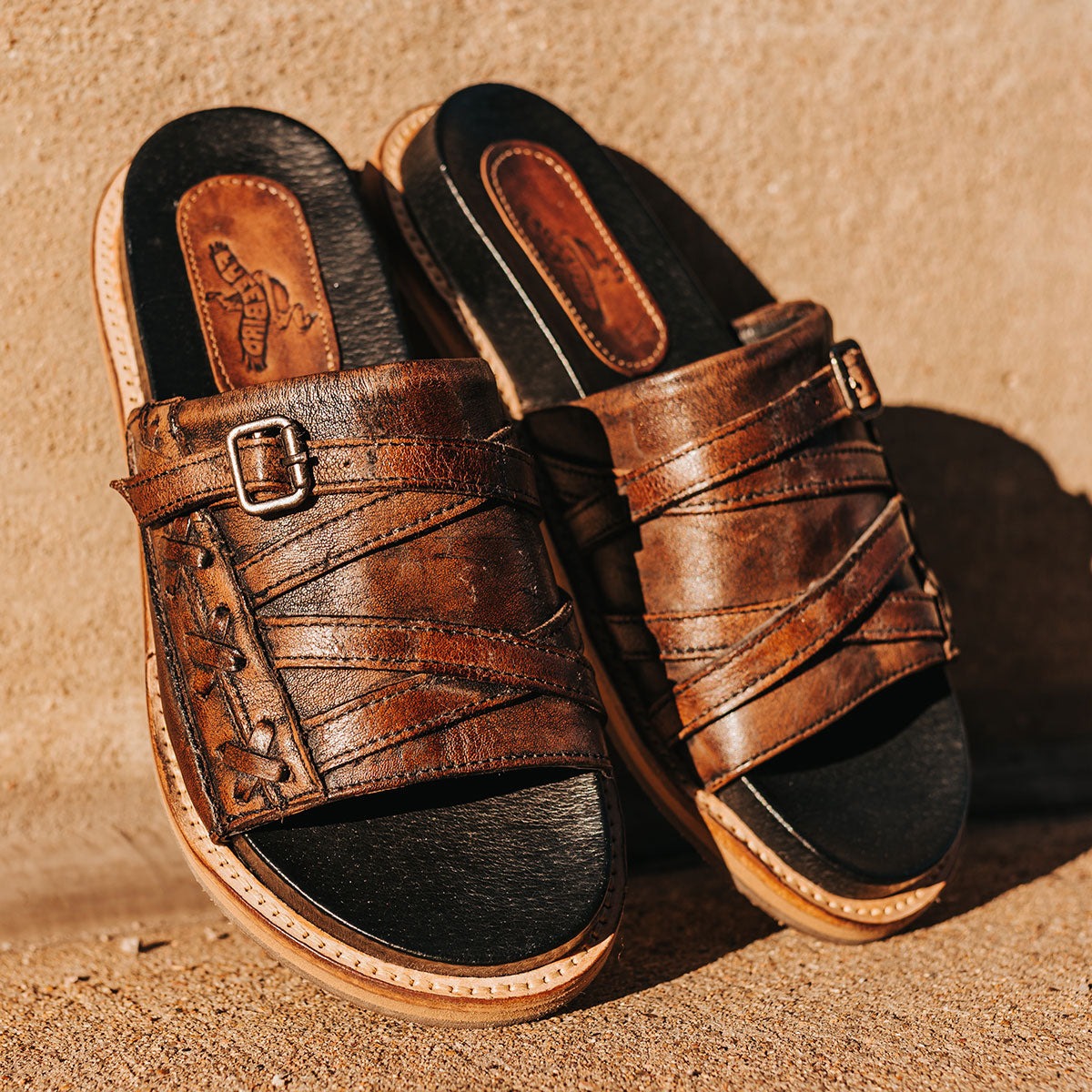 FREEBIRD women's Fleetwood black flat slip-on sandal featuring leather stitch detailing with metal buckle