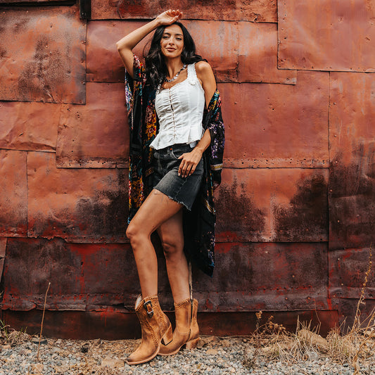 FREEBIRD women's Freya cognac suede bootie with whip stitch detailing, a snip toe silhouette and decorative vintage buckle. Finished with an inside working zipper lifestyle