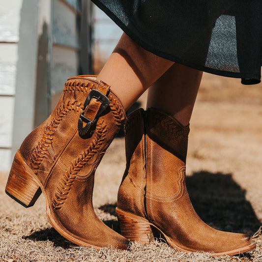 FREEBIRD women's Freya cognac suede bootie with whip stitch detailing, a snip toe silhouette and decorative vintage buckle. Finished with an inside working zipper.
