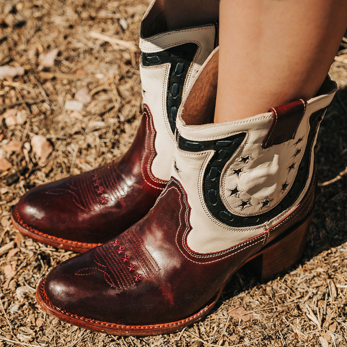 Red multi GAMBLER leather booties with horseshoe overlay, floral embroidery, and Western-style buckstitch detailing.