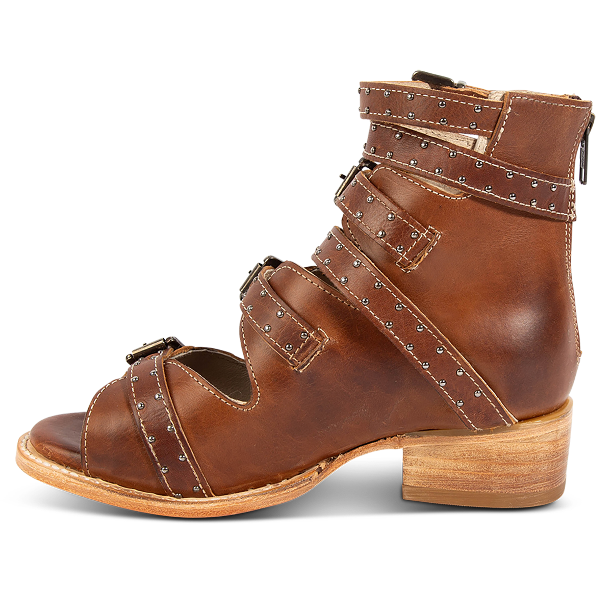 Inside view showing a low block heel, adjustable leather straps and stud embellishments on FREEBIRD women's Gunnar cognac leather sandal