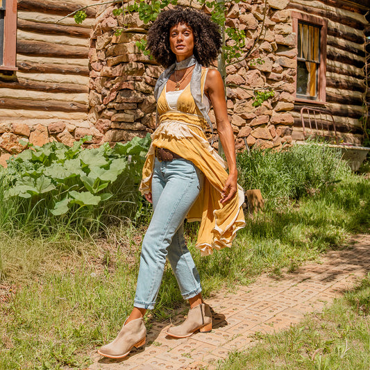 FREEBIRD women's Hippy beige suede low heeled bootie with a working brass zip closure, heel seam embroidery, almond toe, and front dip detailing lifestyle