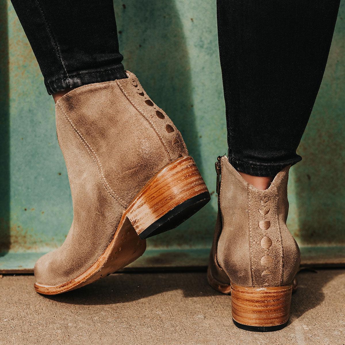 FREEBIRD women's Hippy beige suede low heeled bootie with a working brass zip closure, heel seam embroidery, almond toe, and front dip detailing