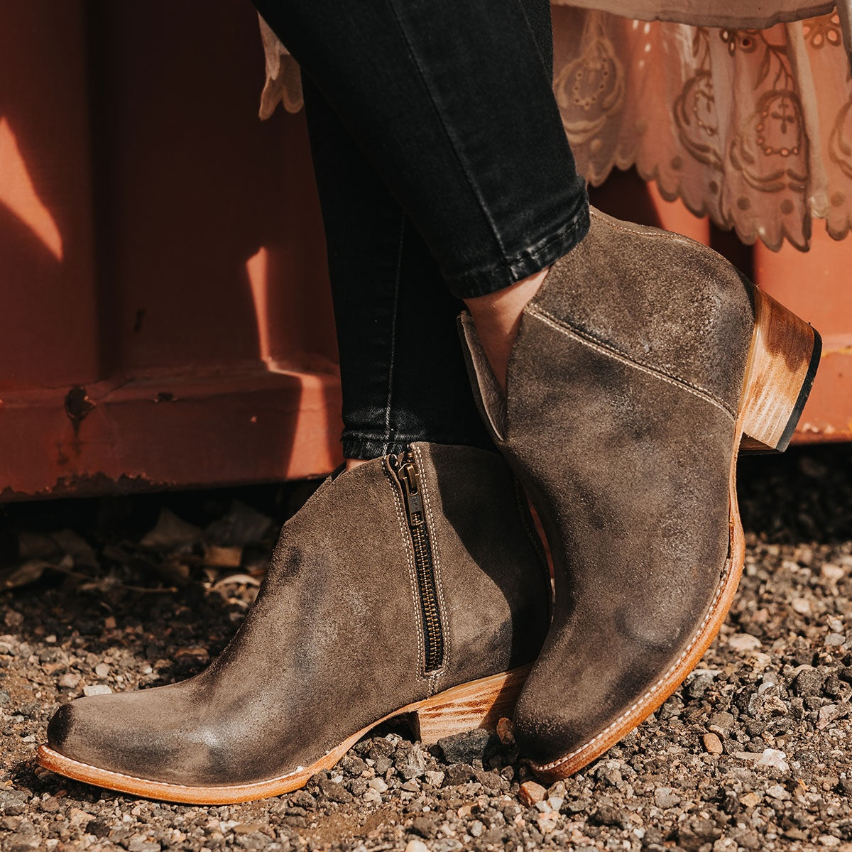 FREEBIRD women's Hippy grey suede low heeled bootie with a working brass zip closure, heel seam embroidery, almond toe, and front dip detailing
