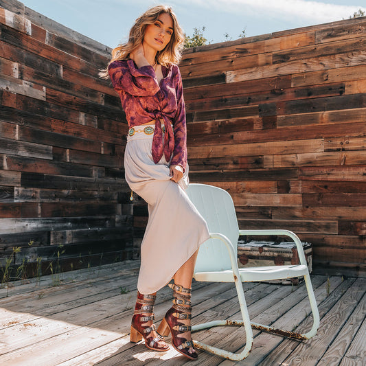 FREEBIRD women's Jett red leather sandal with adjustable gold buckling, a high lifted heel and metallic chevron stitching lifestyle