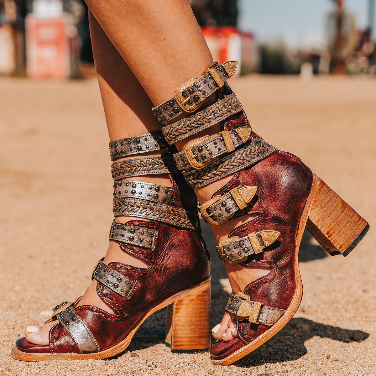 FREEBIRD women's Jett red leather sandal with adjustable gold buckling, a high lifted heel and metallic chevron stitching