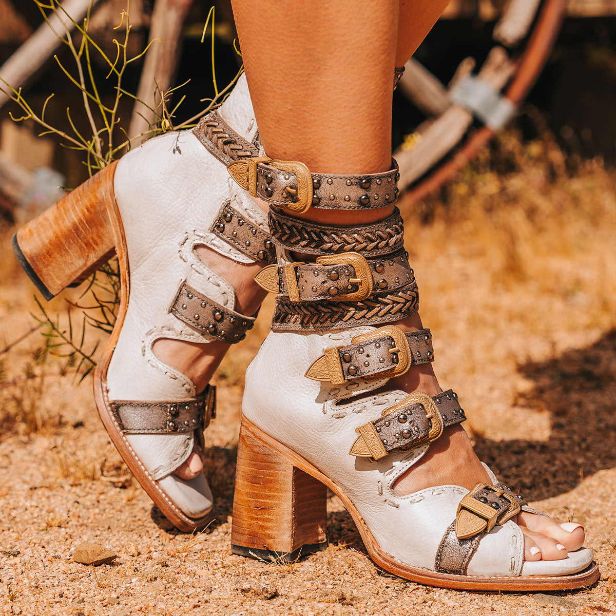 FREEBIRD women's Jett white leather sandal with adjustable gold buckling, a high lifted heel and metallic chevron stitching 