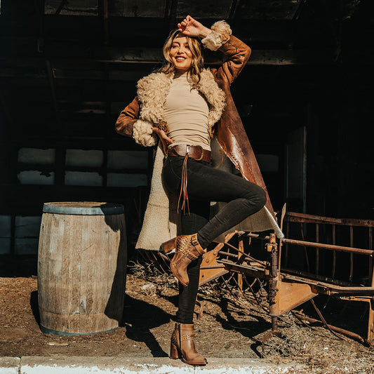 FREEBIRD women's Jovi cognac suede bootie with inside zip closure, flare heel, and stud detailing lifestyle image