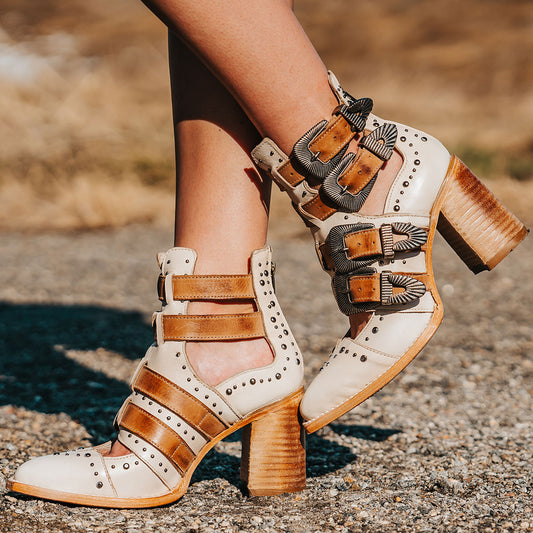FREEBIRD women's Judge off white leather bootie with engraved belts, contrating metal embellishments and a stacked heel