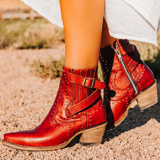 FREEBIRD women's Morgan red leather ankle bootie with silver stud embellishments, gore detailing, and buckle straps