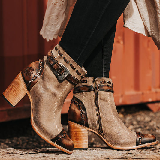 FREEBIRD women's Poppy Beige suede bootie with high heel, inside zip closure, decorative belt, and floral detailing  