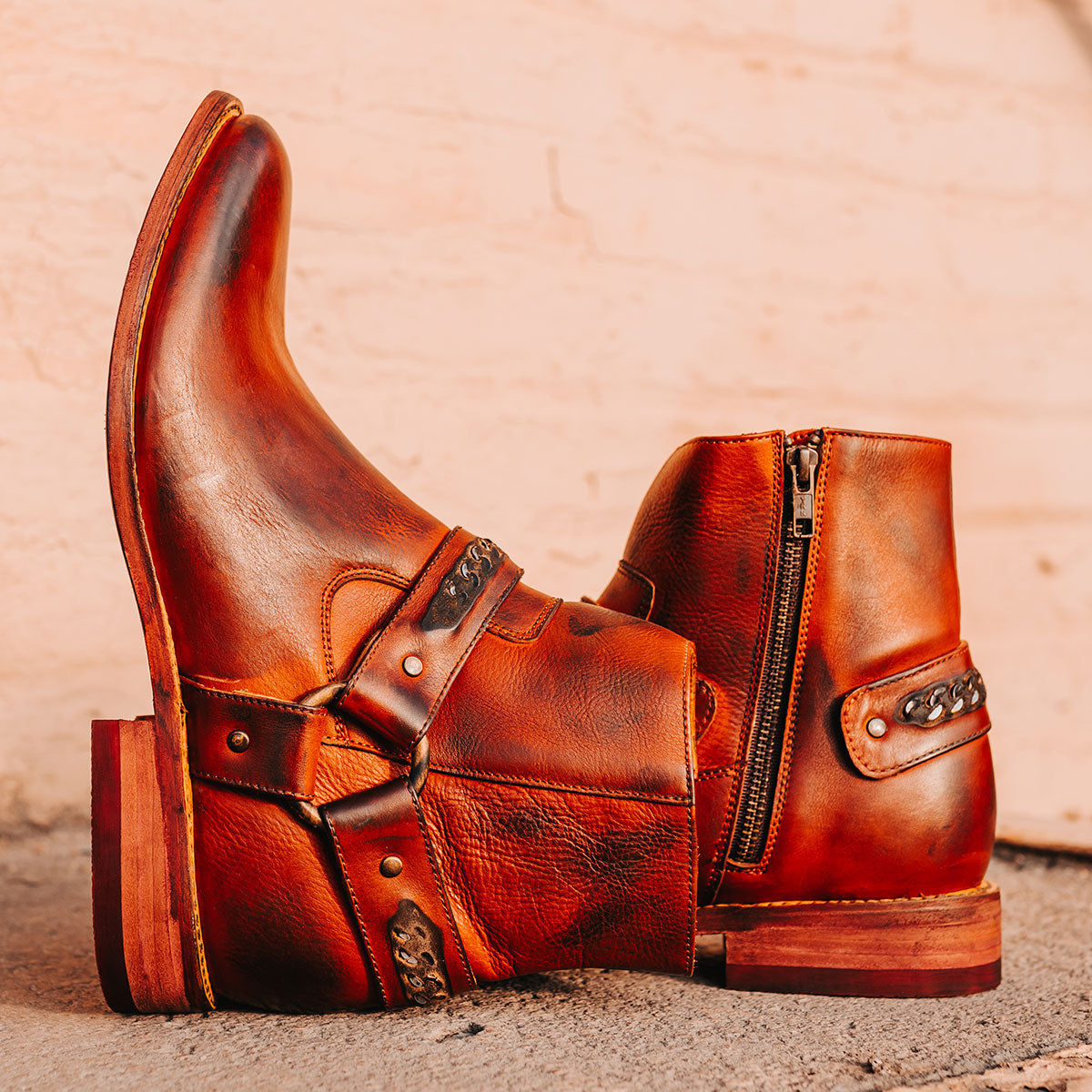 FREEBIRD men's Portland rust leather boot featuring a leather ankle harness with brass chainlink detail, a working inside zip closure and low block heel