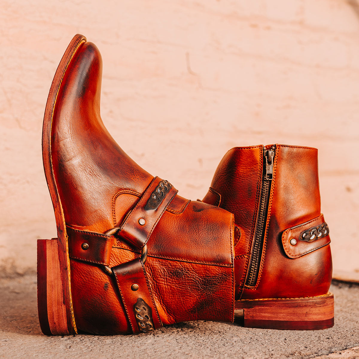 FREEBIRD men's Portland rust leather boot featuring a leather ankle harness with brass chainlink detail, a working inside zip closure and low block heel 