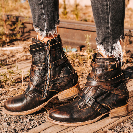 FREEBIRD women's Raine black full grain leather bootie with inside zip closure, wooden heel, and leather overlays with metal buckles