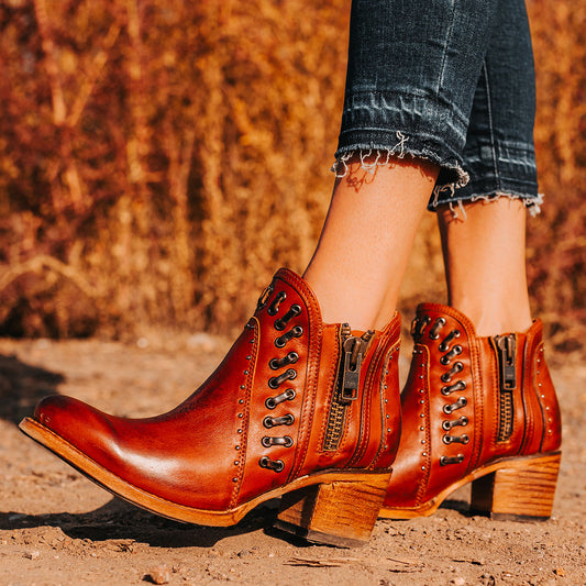 FREEBIRD women's Ryder whiskey leather bootie with inside zip closures, eyelet whip stitch leather detailing and an almond toe