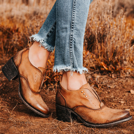 Featuring brogue detailing, silver hardware and distressed leather on FREEBIRD women's Sadie Brown leather Oxford shoe