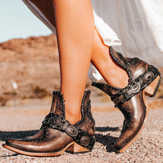 FREEBIRD women's Whimsical black distressed leather bootie with whip stitch detailing, leather braided belt and snip toe construction 