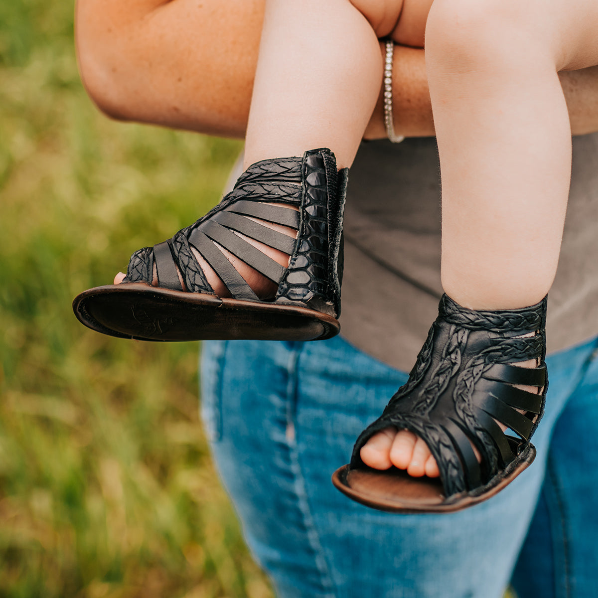 FREEBIRD infant baby bela black sandal with laser-cut leather, braided accents and a back velcro panel.