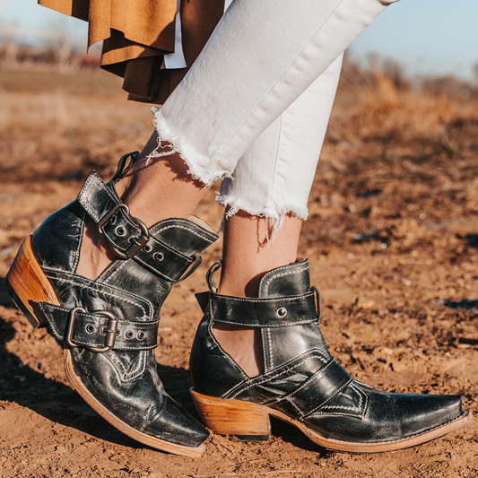 FREEBIRD women's Mayhem black western ankle bootie with exposed sides, adjustable metal buckles, and snip toe